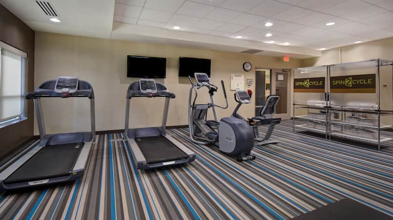 fitness center with machines and towels