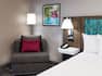 guest room lounge chair, night table, lamp pillows