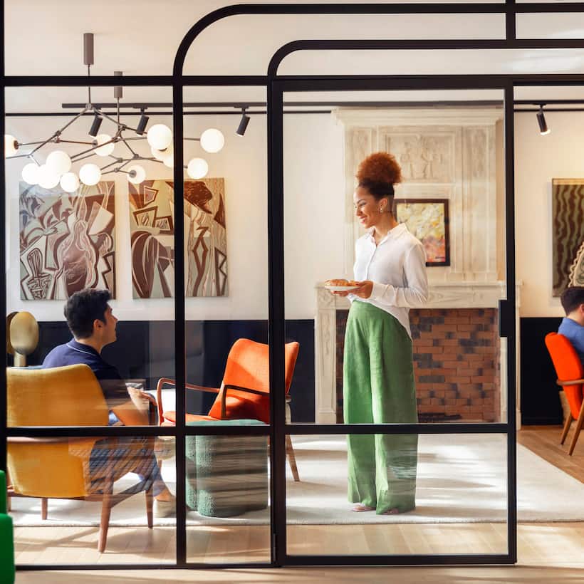 Woman standing in lobby area in discussion with seated man