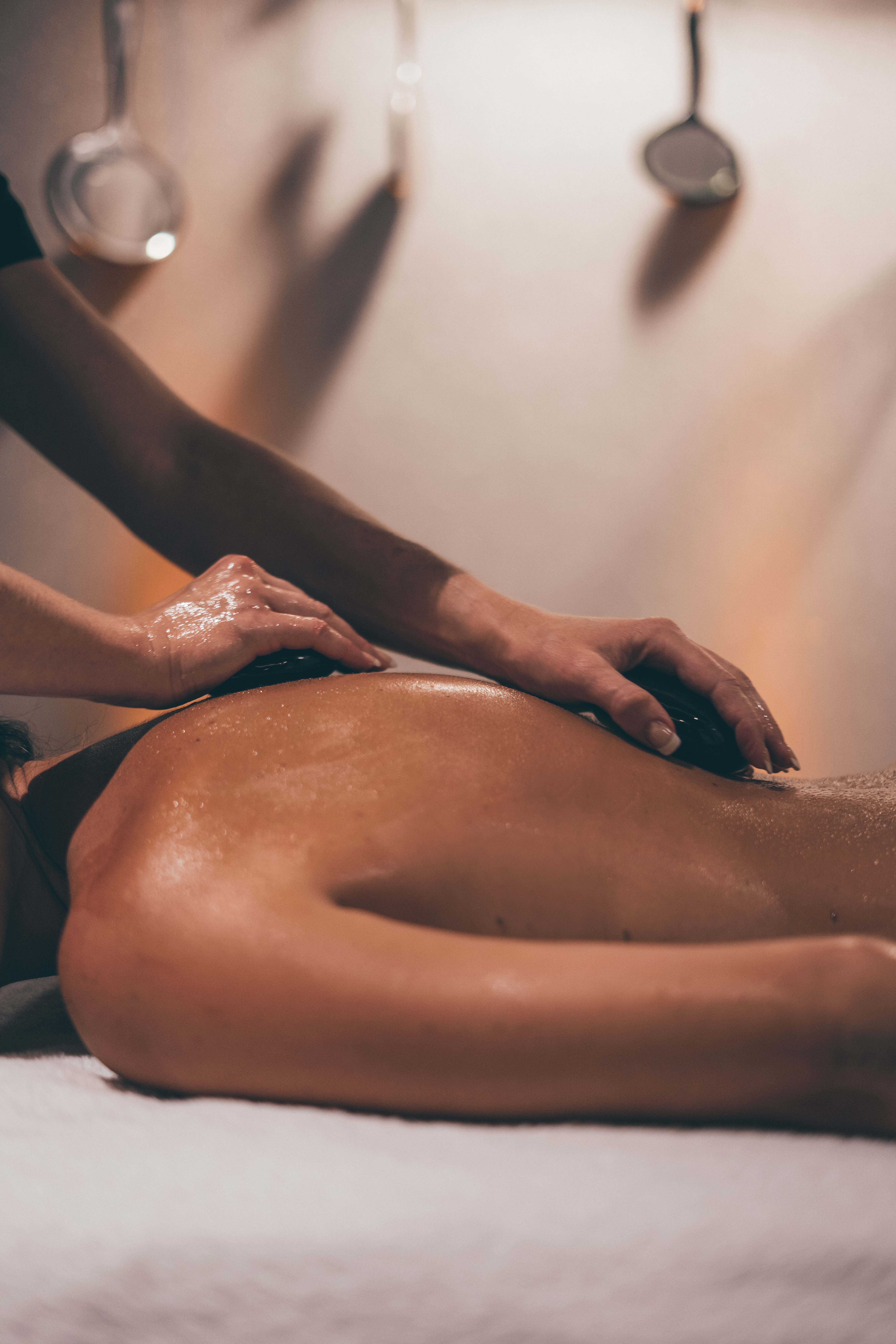 a person enjoying a hot stone massage at the spa