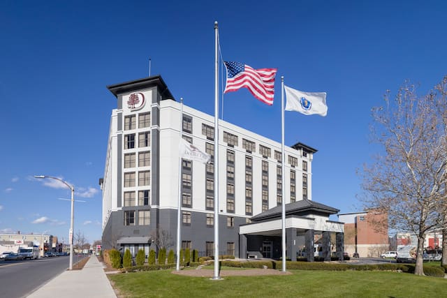 Hotel Building Exterior with Flag Poles at Noon