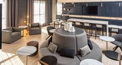 Lobby Seating Area with Armchairs, Tall Chairs, Wall Mounted HDTV and Circular Sofa