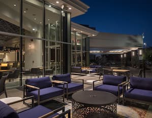 Outdoor lounge area with chairs surrounding coffee table at night
