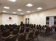 White Rose Meeting Room Arranged Theater Style With Rows of Chairs Facing Projector Screen and Podium