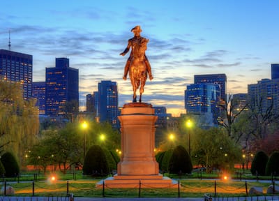 George Washington Statue in Boston Public Garden Illuminated at Sunset With Buildings in the Background