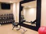 TV, Free Weights, Weight Bench, Large Mirror and Red Exercise Ball in Fitness Center