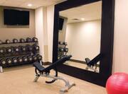 TV, Free Weights, Weight Bench, Large Mirror and Red Exercise Ball in Fitness Center