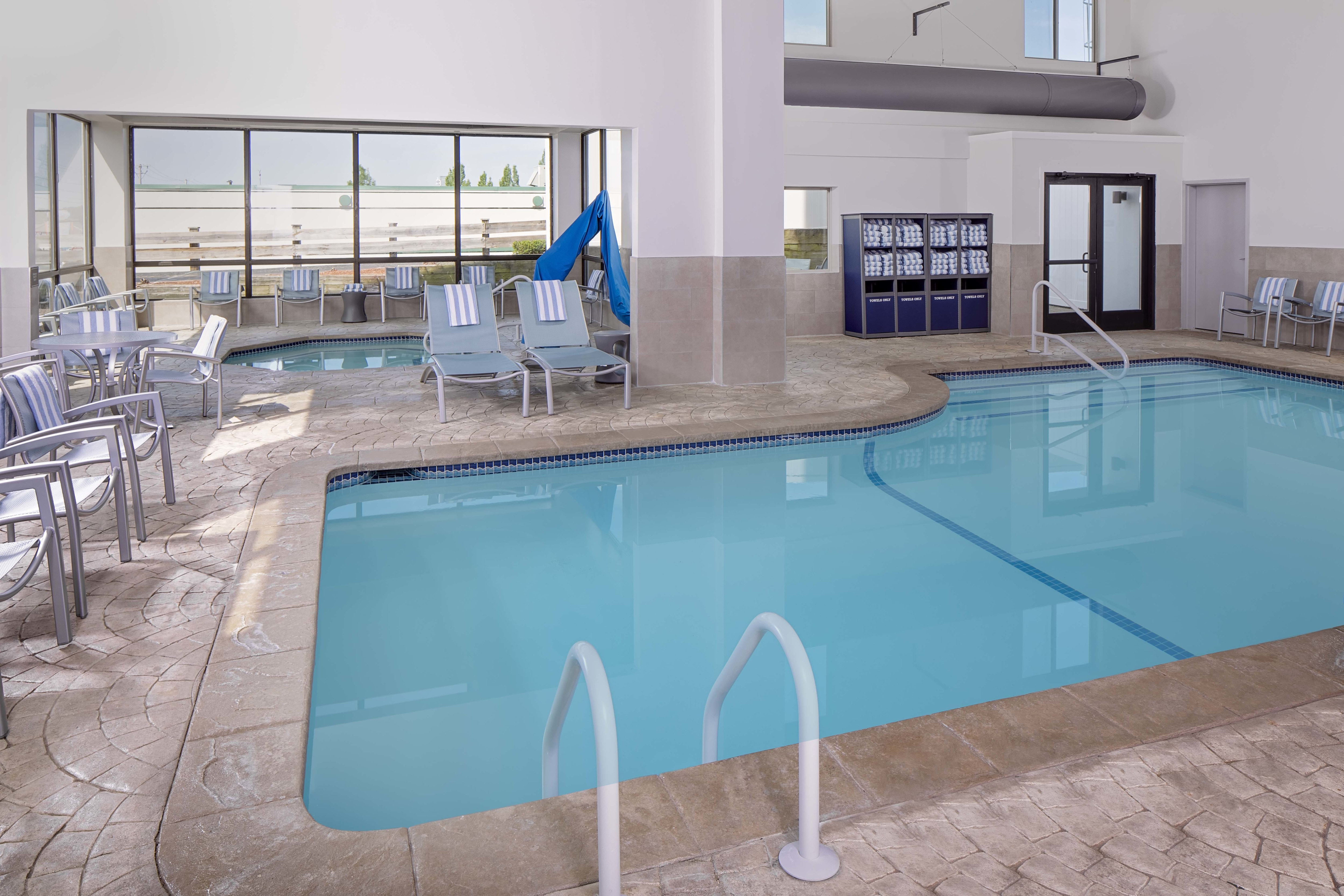 indoor pool and whirlpool with lounge chairs 
