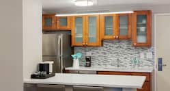 Guestroom Kitchenette with Cabinets, Room Technology, Counter, and Chairs