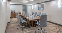 Refreshment Station, Wall Art, and Leather Chairs Around Table in Executive Boardroom