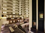 Hotel Atrium With Lounge Seating and Views of Stairs, Elevator Bays, and Guest Room Suite Balconies
