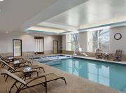 Tables, Chairs, and Relaxation Loungers by Heated Indoor Pool