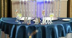 Wedding Table With Place Settings and "Mr. & Mrs" Decor on Blue Linens