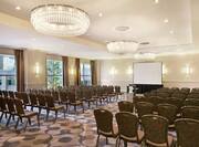 Charles River Ballroom WIth Large Windows and Rows of Chairs Arranged Theater Style and Facing Projector Screen