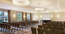 Charles River Ballroom WIth Large Windows and Rows of Chairs Arranged Theater Style and Facing Projector Screen