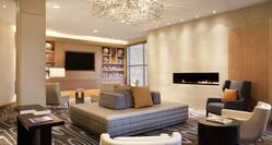 Soft Seating Around Fireplace in Lobby Lounge Area With TV and Window