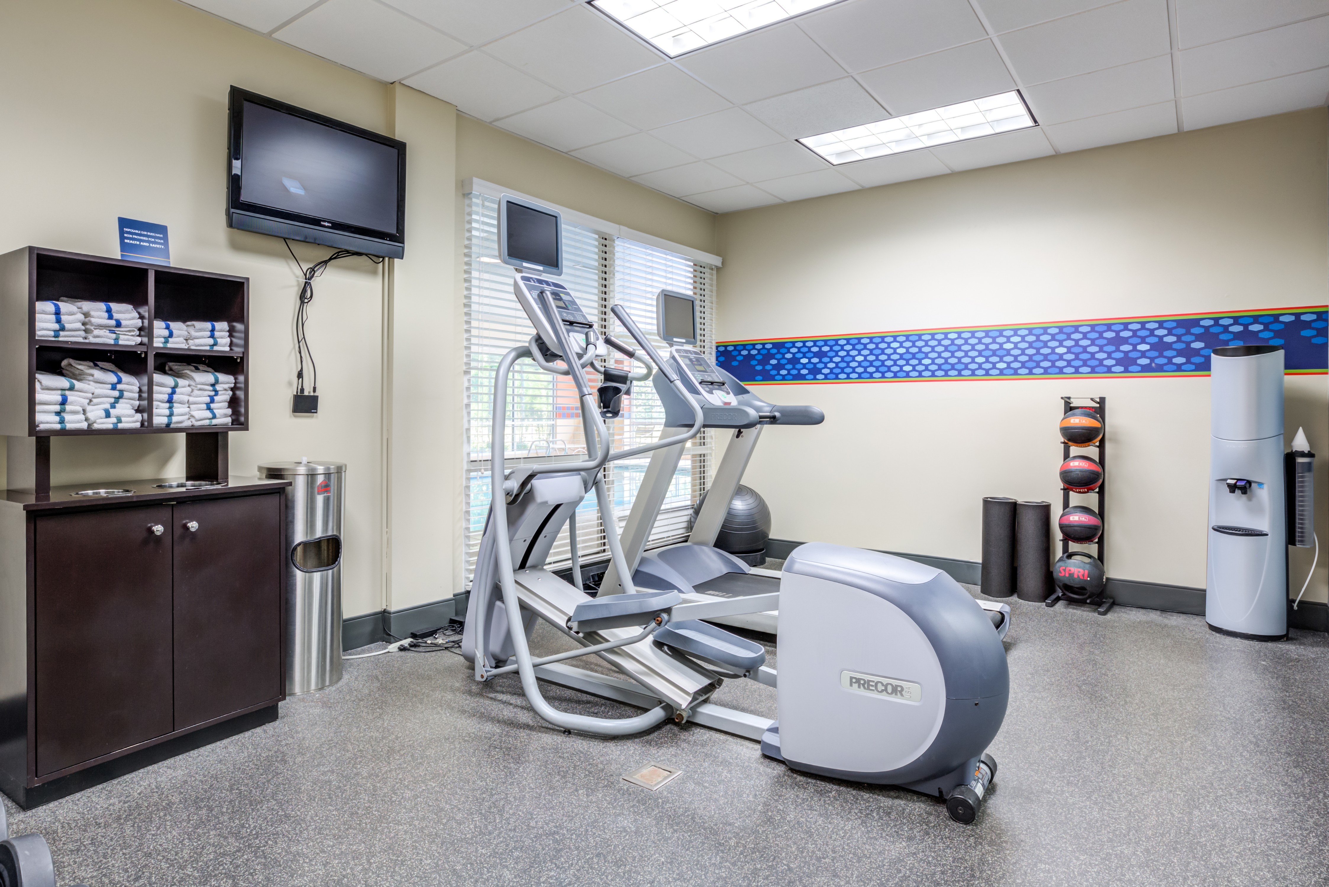 Fitness Center with Exercise Equipment, Towels and a Wall Mounted TV