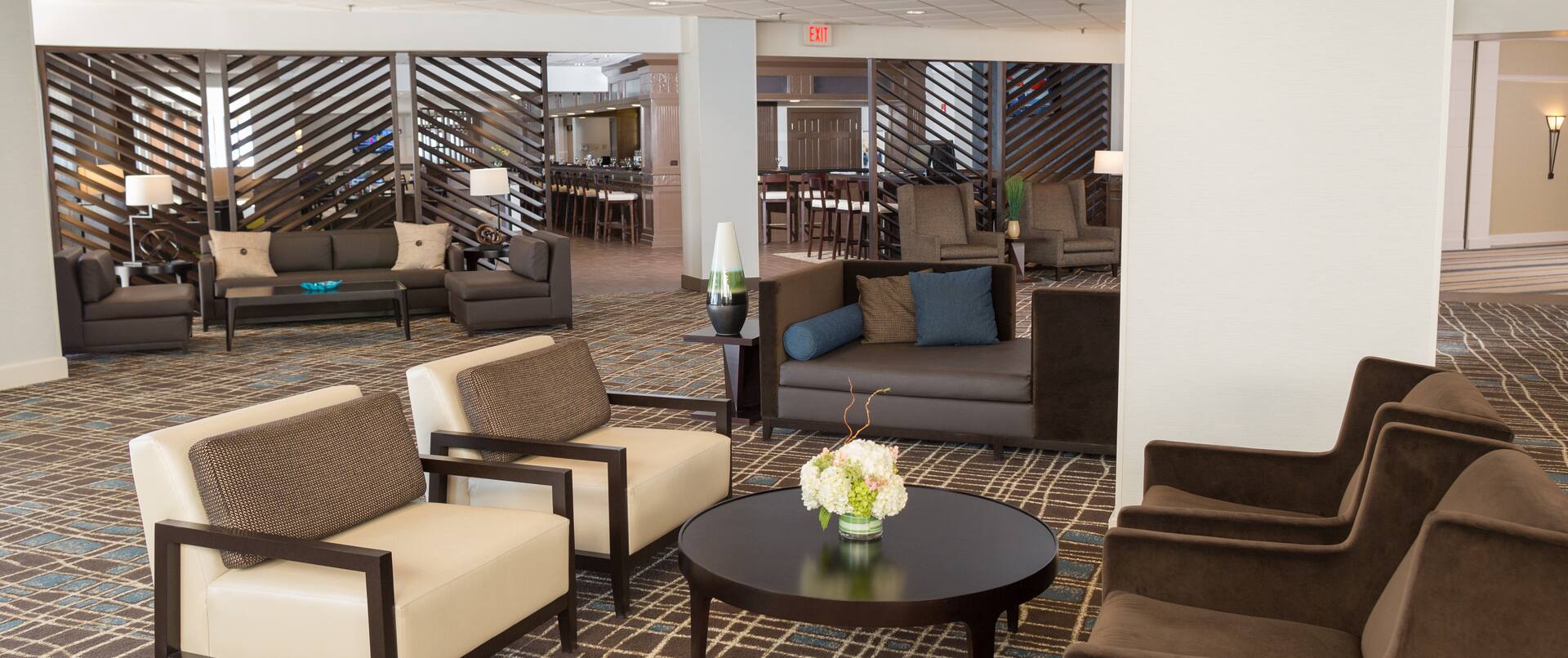 Soft Seating Around Tables and Illuminated Lamps in Lobby Lounge