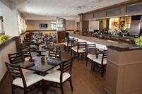 TV, Tables, Chairs, and Bar Seating in Dining Area of Regatta Grille