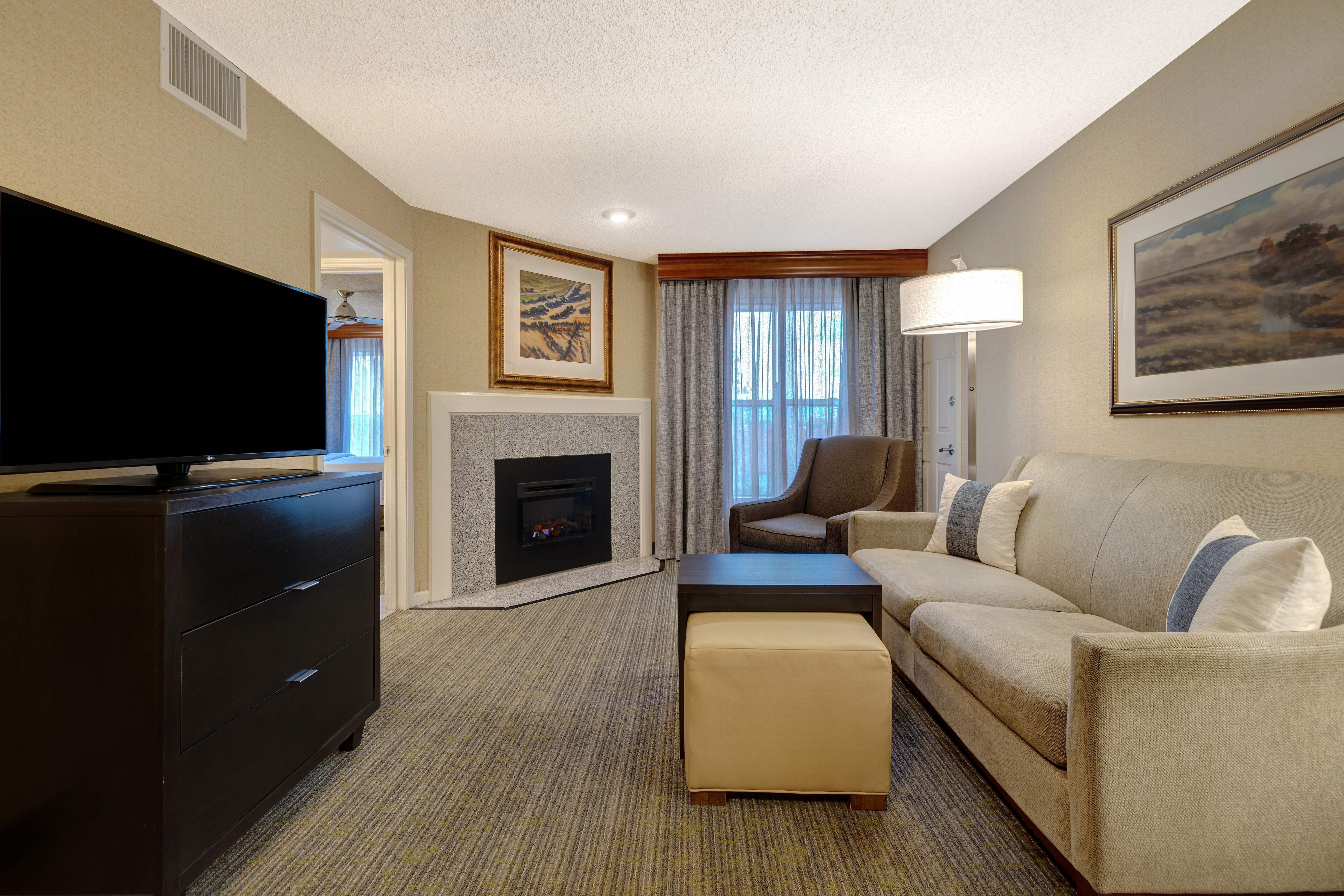 guest room lounge area with tv fireplace and window