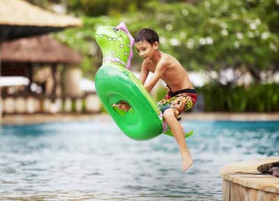 Kid Jumping Into Pool with Inflatable