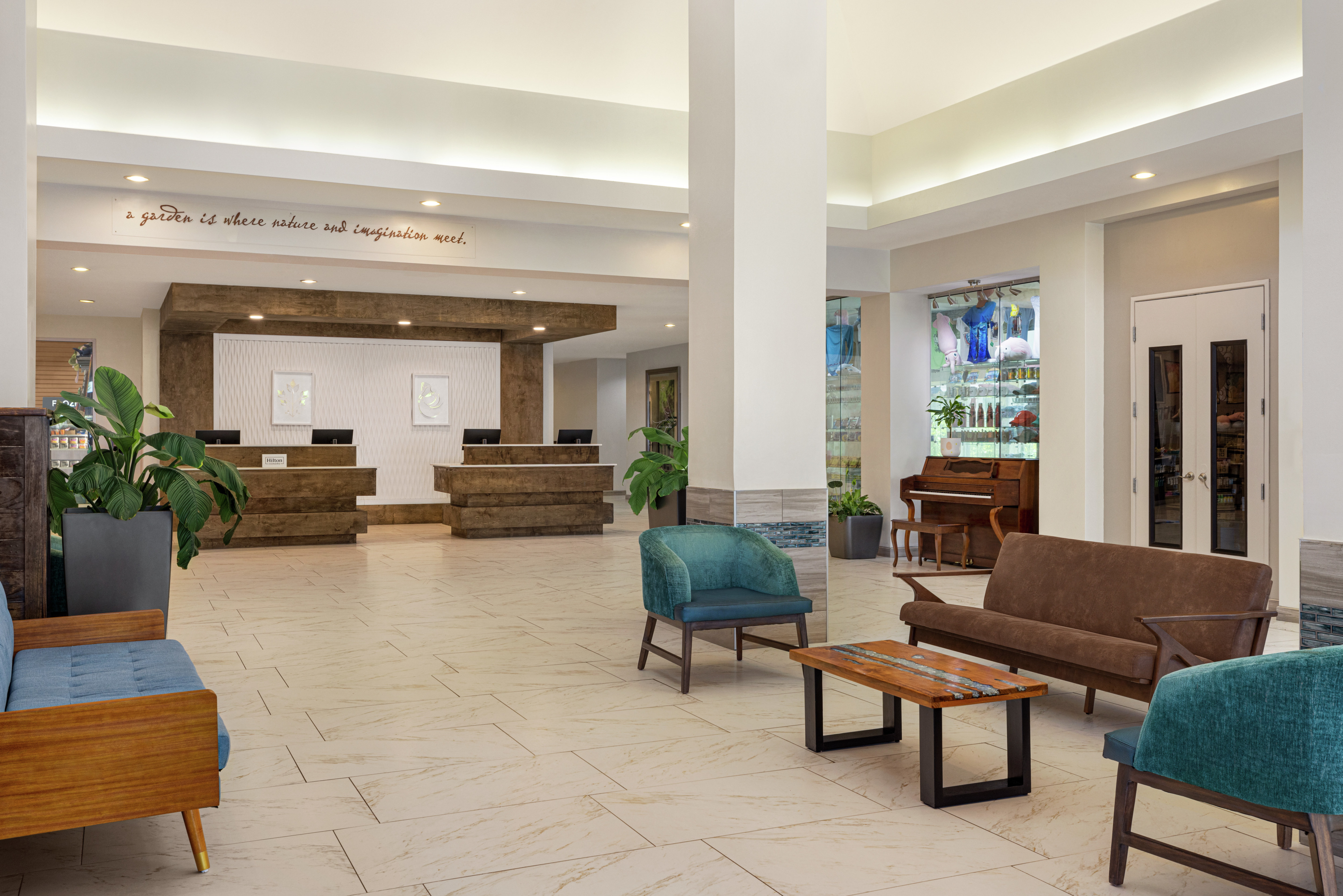 Spacious hotel lobby featuring ample comfortable seating, welcoming front desk, and convenient gift shop.
