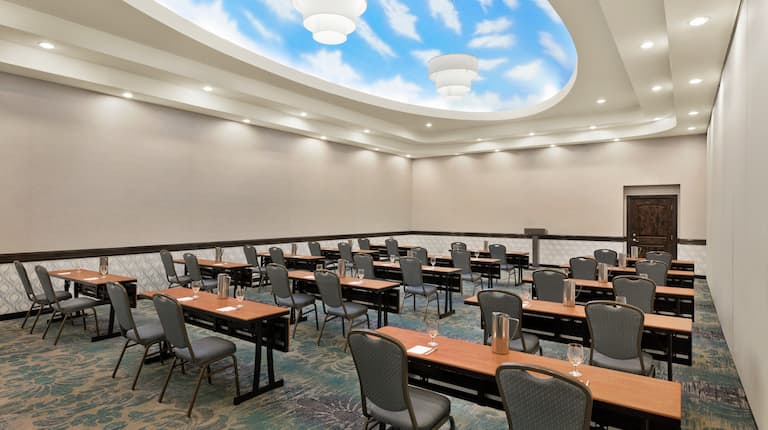Amplia sala de reunión en las instalaciones que ofrece detalles deslumbrantes con montaje tipo aula.