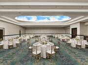 Spacious on-site meeting room with stunning ceiling detail featuring a banquet style setup.