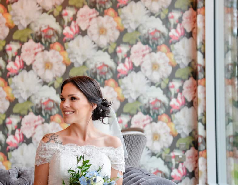 Bride with bouquet sitting on sofa