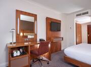 Hospitality Center, Work Desk, TV, Entry, and Queen Bed in Standard Room