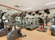 Fitness Center With Mirrored Walls, TVs, and Cardio Equipment