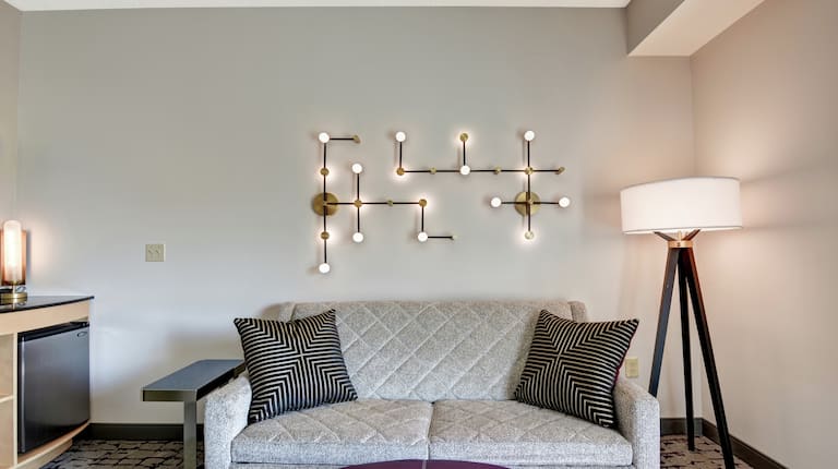 Guestroom seating area with couch and decorative lamps