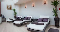 Three Loungers With Purple Pillows in Relaxing Area of Wellness Spa