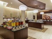 Beverages, Plates, Utensils, Hot and Cold Buffet Selections on Counters of Breakfast Service Area