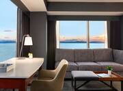 Guest Room Living Area with Desk and Panoramic Views of Lake