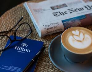 Eine Zeitung und eine Tasse Kaffee auf einem Tisch