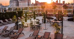 Rooftop Terrace with Tables and Chairs at Sunset 
