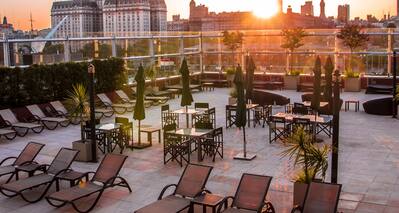 Rooftop Terrace with Tables and Chairs at Sunset 