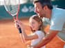 a Man Teaching a Girl Holding a Tennis Racket How to Play