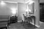 Work desk with mirror hanging above it in guest room