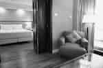 Chair in lounge area with door leading to bedroom area