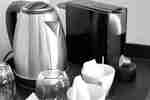 Tea kettle, coffee maker and cups on counter