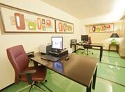 Business Center With Green Floors, Colorful Wall Art, Two Work Desks With Computers and Printers