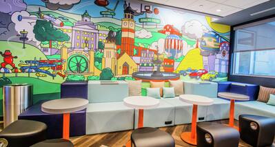 Mural on Wall in Lounge Area with Tables and Chairs