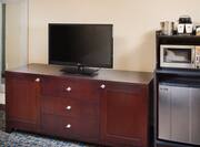 Detailed View of TV on Media Cabinet, and Hospitality Center With Coffeemaker, Microwave, and Fridge  