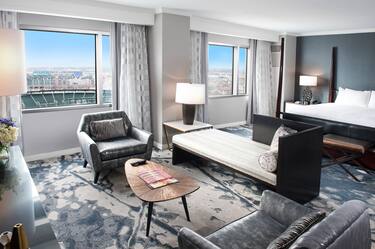 One King Bed Guest Suite with Two Armchairs, Coffee Table and Stadium View