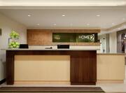 Hotel Signage and Computers Behind Reception Desk With Green Apples on the Counter