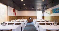 Classroom Setup in The Pier Meeting Room of EJ's Provision Company Restaurant With Tables and Chairs Facing Podium