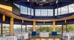 Spacious Ballroom Dining Area with Roundtables, Chairs and Harbor View
