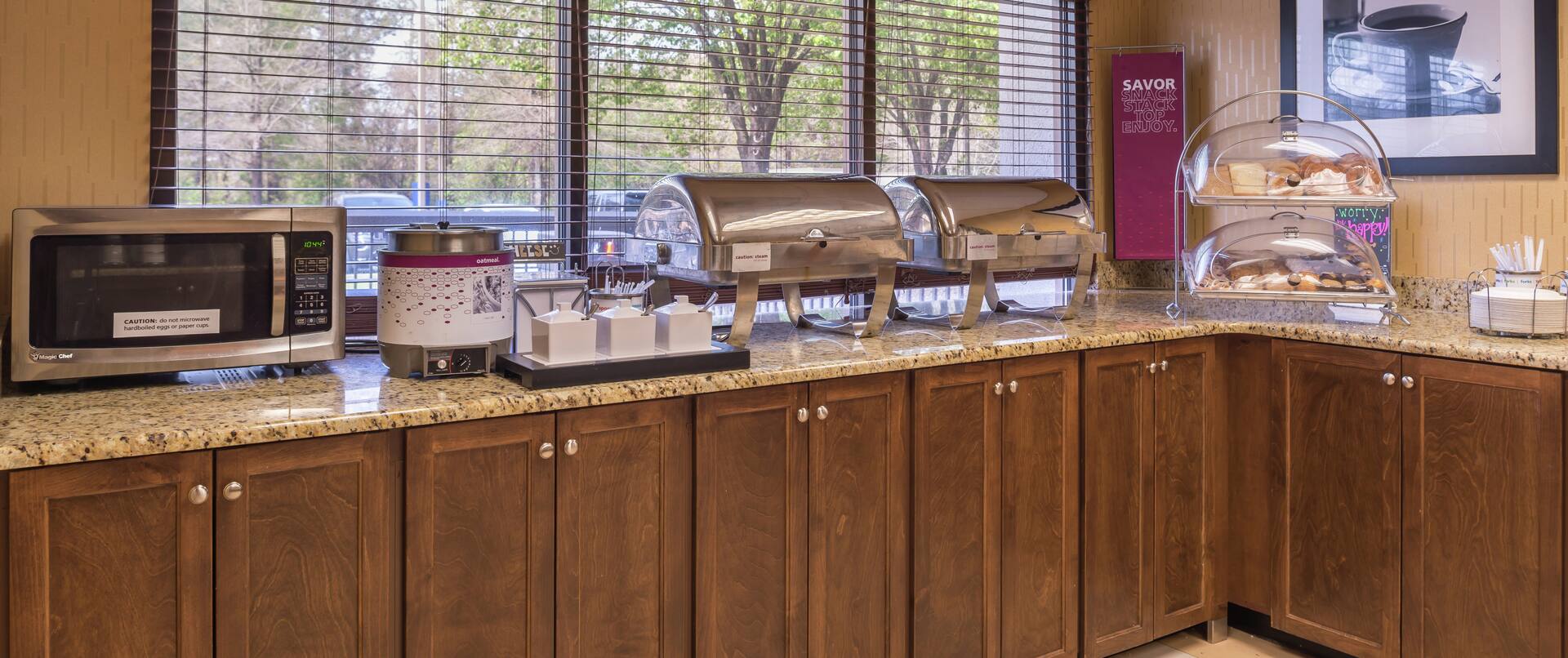 Breakfast Service Area with Microwave, Plates, Utensils, Hot and Cold Buffet Items